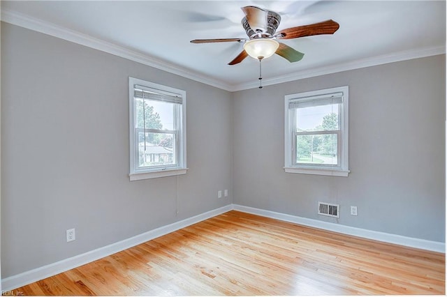 empty room with ceiling fan, a healthy amount of sunlight, crown molding, and light hardwood / wood-style flooring