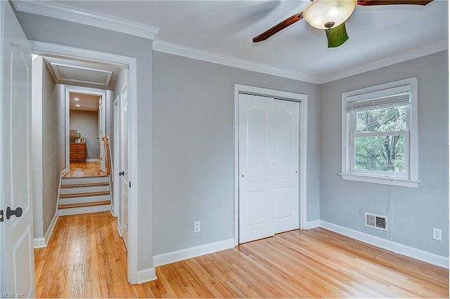 unfurnished bedroom with light wood-type flooring, a closet, ceiling fan, and ornamental molding