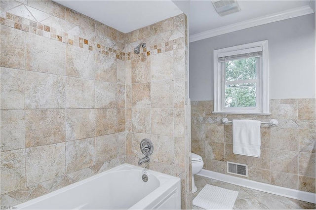 bathroom featuring tiled shower / bath combo, toilet, tile walls, and ornamental molding