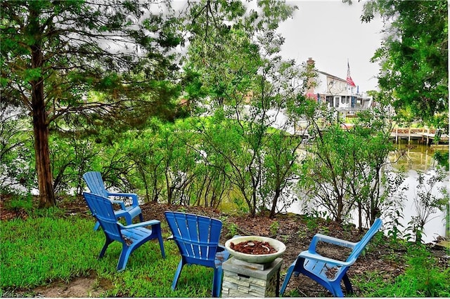 view of yard with a water view and an outdoor fire pit