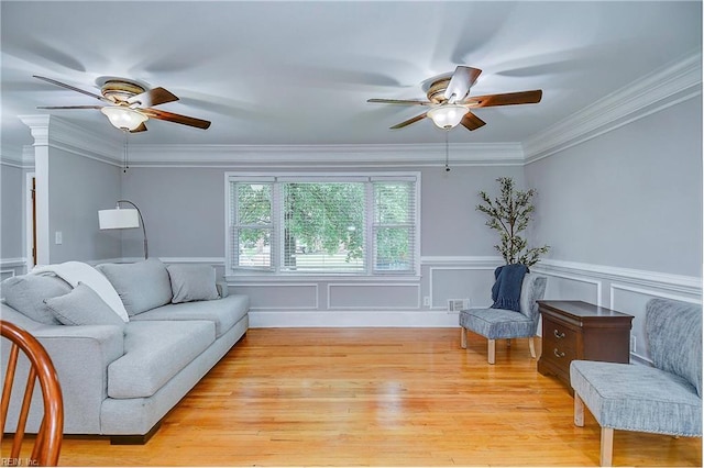 living room featuring ceiling fan, light hardwood / wood-style floors, and crown molding