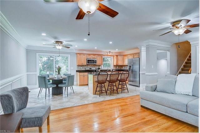 living room featuring sink, light tile patterned floors, and ornamental molding