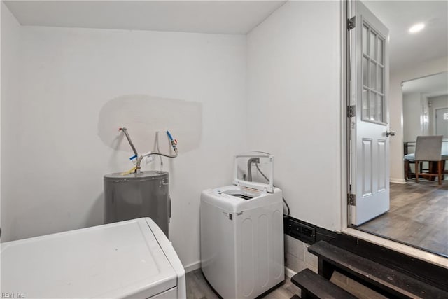 laundry area featuring hardwood / wood-style flooring, washer and clothes dryer, and electric water heater