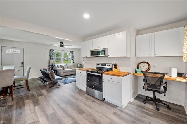 kitchen featuring wood counters, light hardwood / wood-style flooring, white cabinets, and appliances with stainless steel finishes