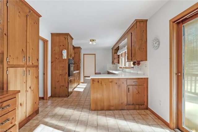 kitchen with sink, kitchen peninsula, and oven