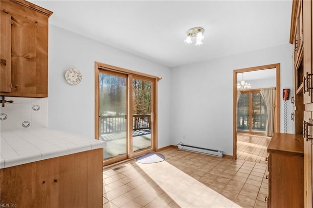 doorway with baseboard heating and an inviting chandelier