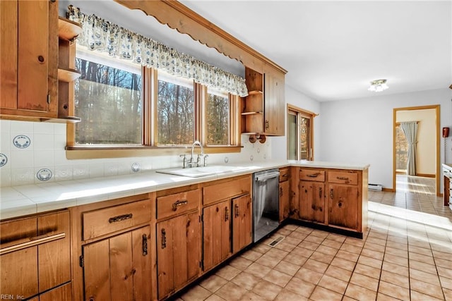 kitchen with light tile patterned floors, tile countertops, decorative backsplash, dishwasher, and sink