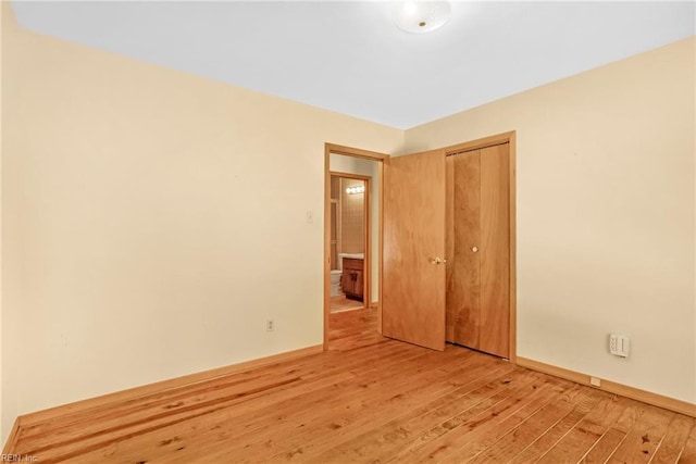 unfurnished bedroom featuring a closet and light hardwood / wood-style flooring