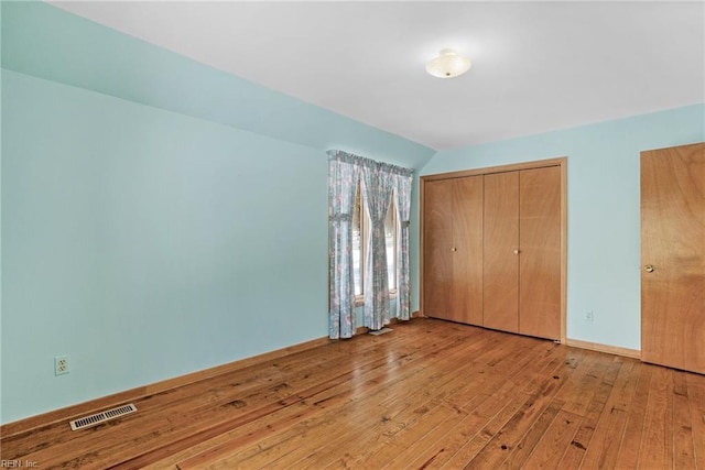 unfurnished bedroom with a closet and light hardwood / wood-style flooring