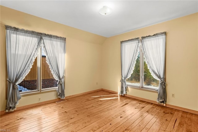 unfurnished room with lofted ceiling and light hardwood / wood-style floors