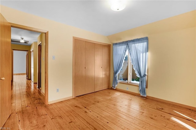 unfurnished bedroom with a closet and light wood-type flooring