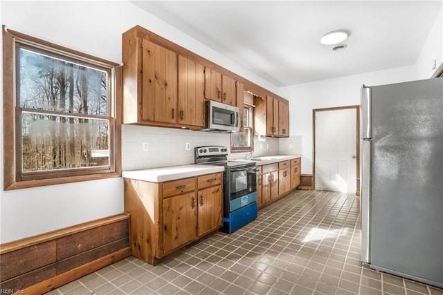 kitchen with decorative backsplash and appliances with stainless steel finishes