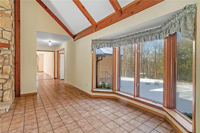 unfurnished room featuring high vaulted ceiling, plenty of natural light, beamed ceiling, and light tile patterned flooring