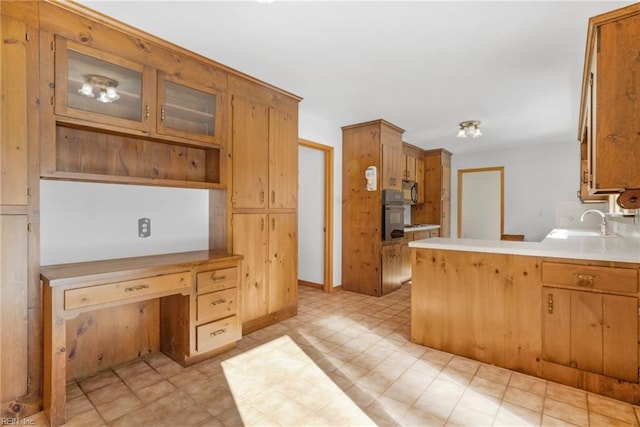 kitchen with sink, black appliances, and kitchen peninsula