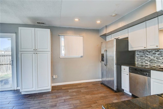 kitchen featuring stainless steel appliances, white cabinetry, and dark wood-type flooring