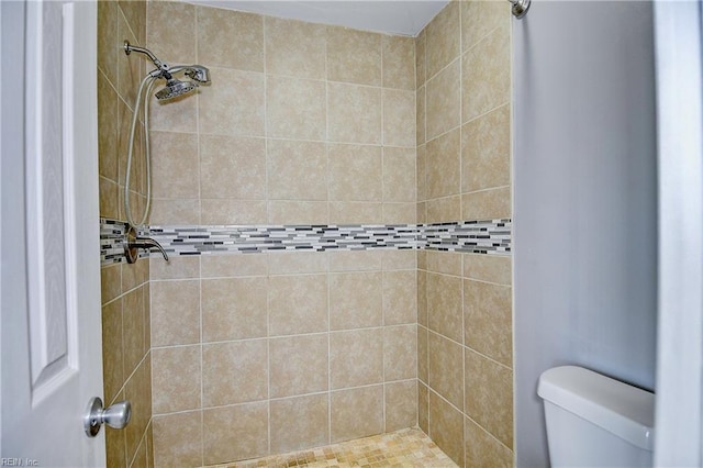 bathroom with toilet and tiled shower