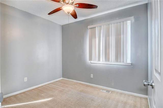 carpeted empty room featuring ceiling fan and plenty of natural light