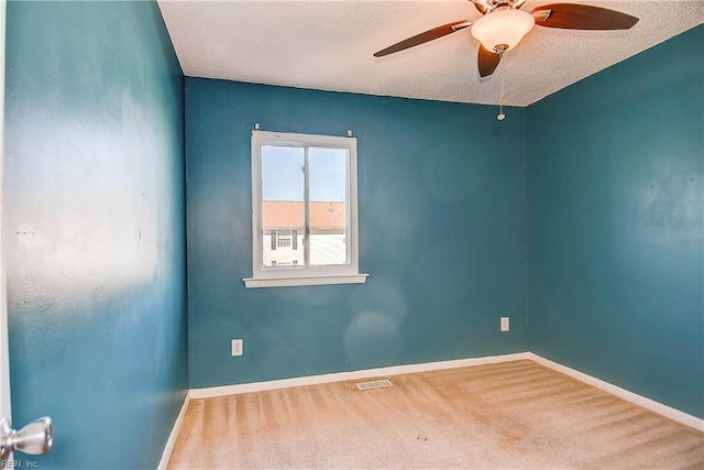 carpeted spare room featuring ceiling fan and a textured ceiling