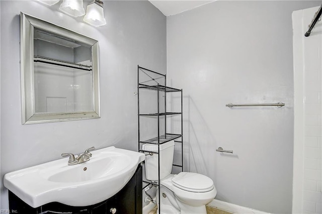 bathroom with a shower, vanity, and toilet