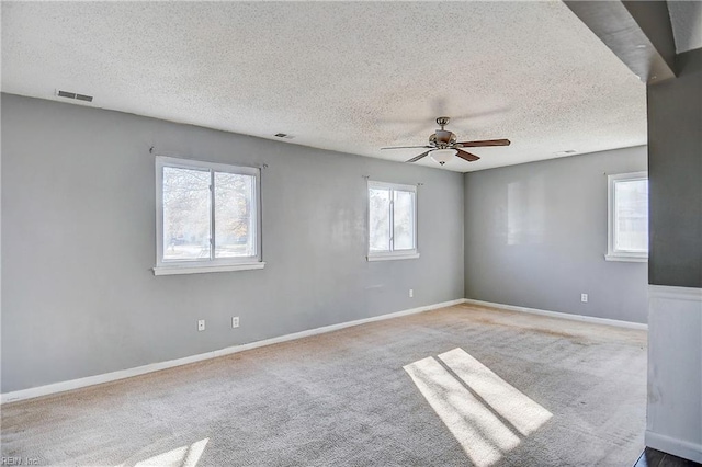 spare room featuring carpet, ceiling fan, and a textured ceiling