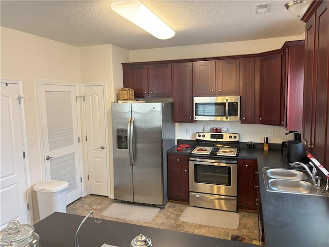 kitchen featuring a textured ceiling, sink, and stainless steel appliances