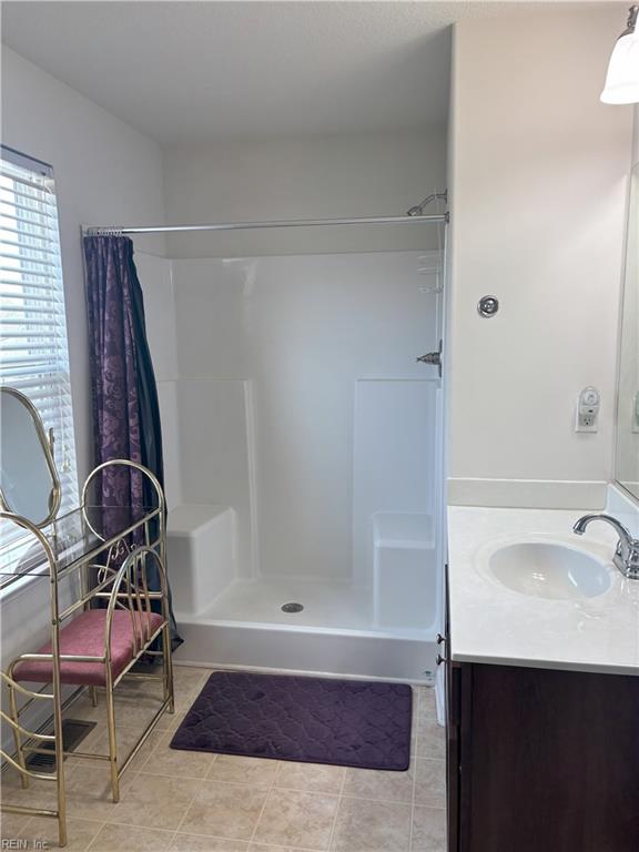 bathroom with tile patterned flooring, a shower with curtain, and vanity