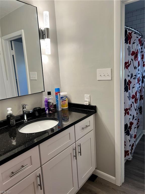 bathroom with vanity, hardwood / wood-style flooring, and walk in shower