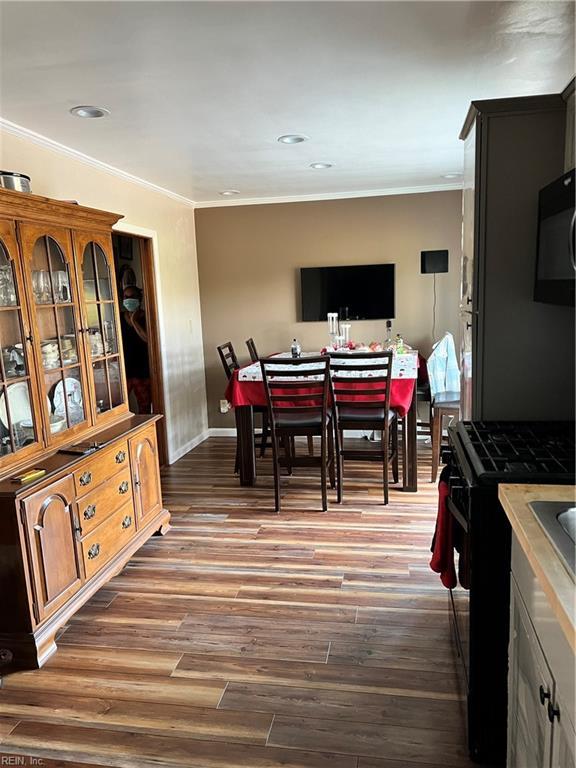 dining area with hardwood / wood-style flooring and crown molding