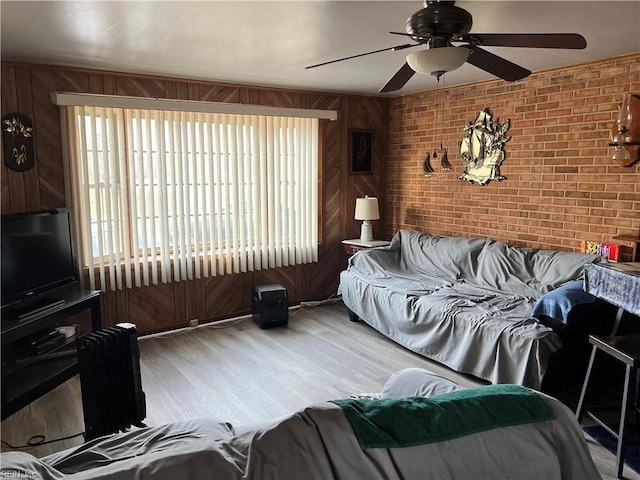 living room featuring plenty of natural light, ceiling fan, and brick wall