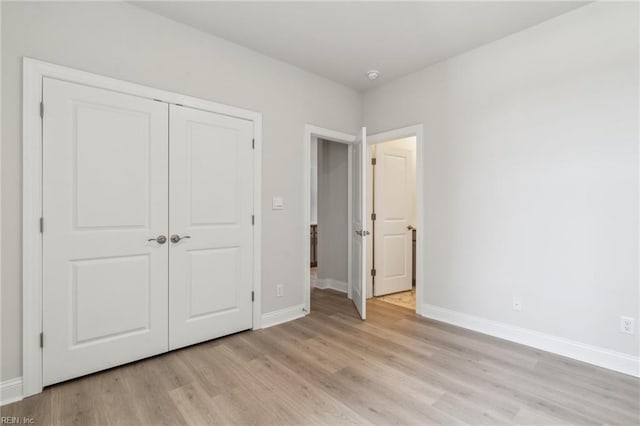 unfurnished bedroom featuring light hardwood / wood-style floors and a closet