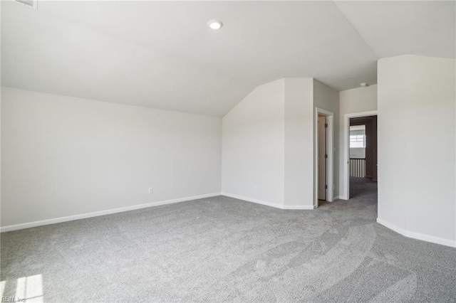 additional living space with carpet flooring and lofted ceiling