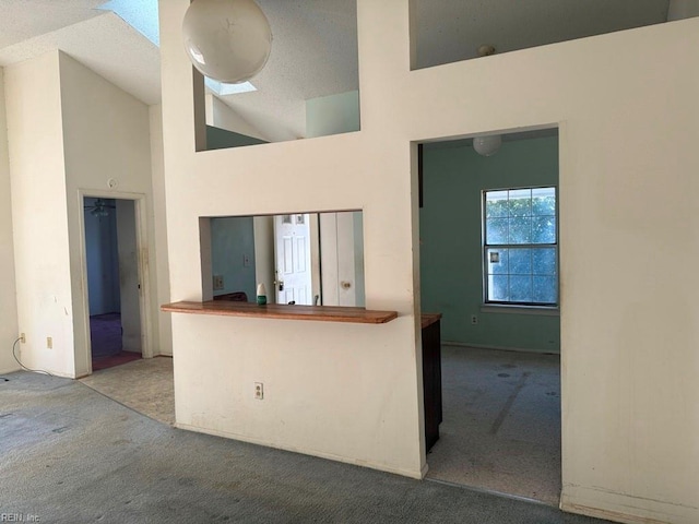 kitchen with carpet flooring and high vaulted ceiling