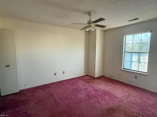 carpeted empty room with a textured ceiling and ceiling fan