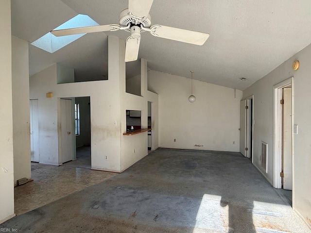 unfurnished living room featuring a skylight, high vaulted ceiling, and ceiling fan