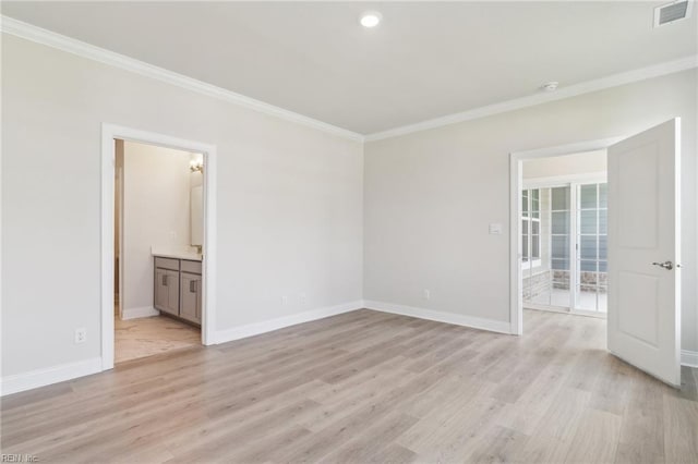 empty room featuring crown molding and light hardwood / wood-style floors