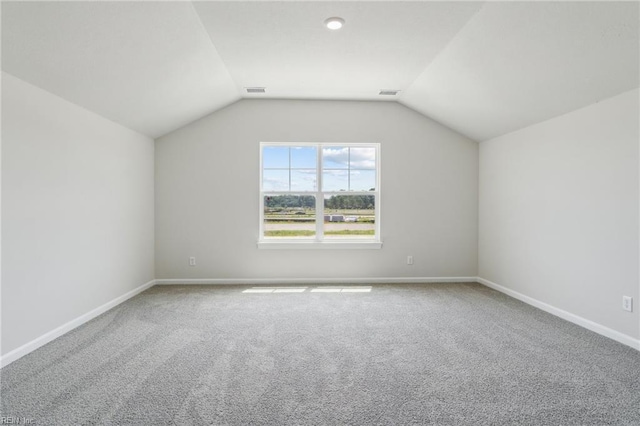 additional living space with carpet floors and vaulted ceiling