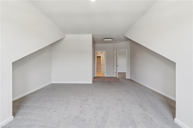 additional living space with light colored carpet and lofted ceiling