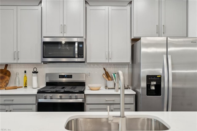 1232 Treviso Bay, Williamsburg, VA 23188 - kitchen with decorative backsplash, stainless steel appliances, light countertops, and a sink