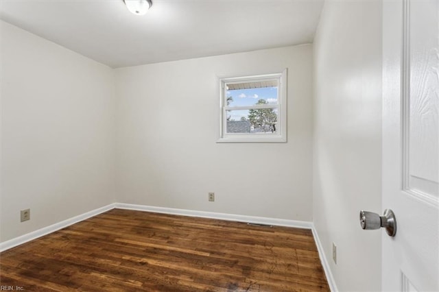 spare room featuring dark wood-type flooring