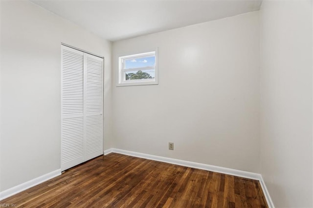 unfurnished bedroom with a closet and dark hardwood / wood-style floors