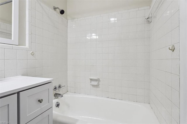 bathroom with vanity, tile walls, and tiled shower / bath