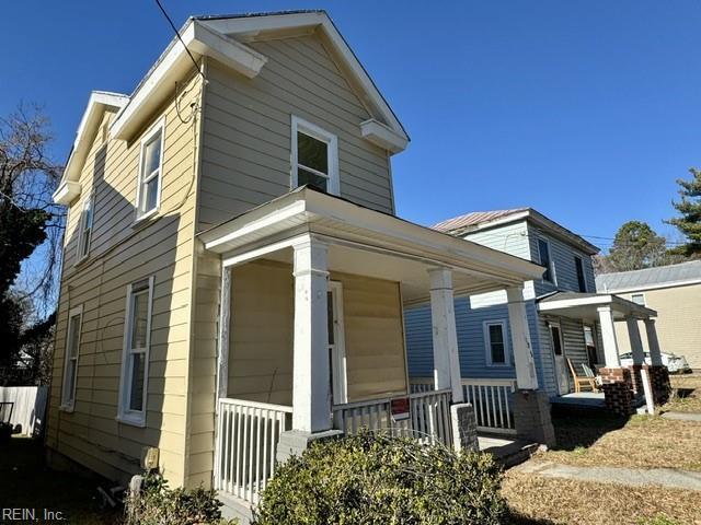 view of side of home featuring covered porch