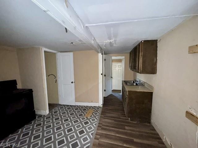 interior space with dark brown cabinets, dark hardwood / wood-style flooring, and sink