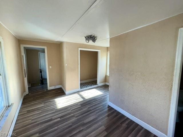 unfurnished room with dark wood-type flooring