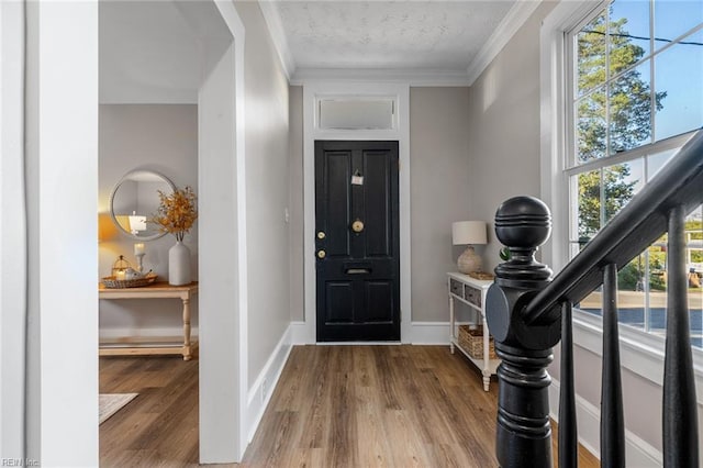 entrance foyer featuring crown molding, wood-type flooring, and a textured ceiling