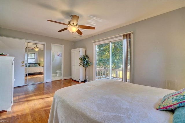 bedroom featuring hardwood / wood-style flooring, ceiling fan, connected bathroom, and multiple windows