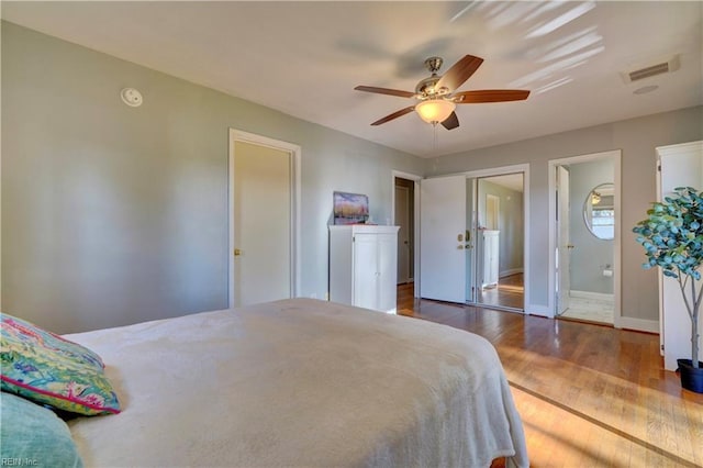 bedroom with ensuite bathroom, hardwood / wood-style floors, and ceiling fan