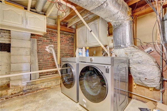 laundry area with washer and dryer and cabinets