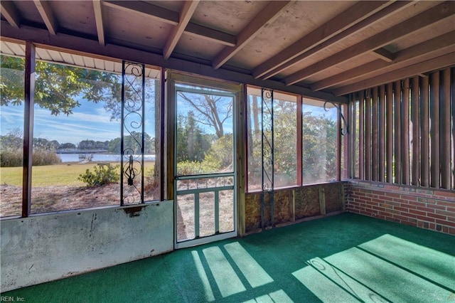 unfurnished sunroom featuring a water view