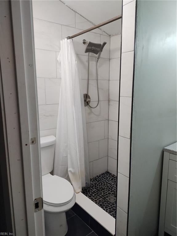 bathroom with curtained shower and toilet